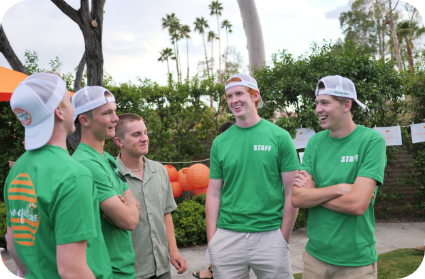 Gallery - a photo of 5 man talking and laughing, 4 of them are wearing Croquet uniform in green.